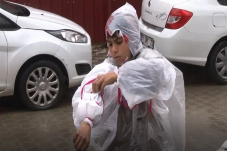 Suriyeli çocuk yağmurda karton toplayabilmek için poşetlerden kıyafet yaptı